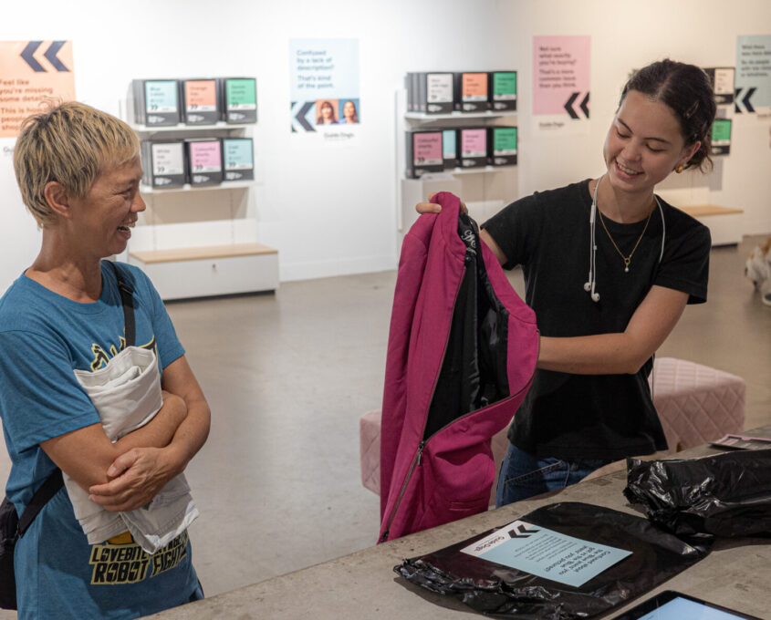 A person unboxing a pink jacket.