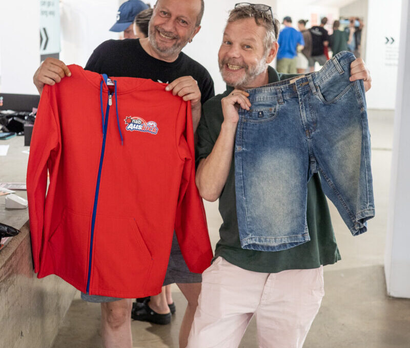 Two people holding up their items and smiling,