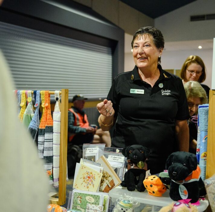 Merran at a stall talking to people.