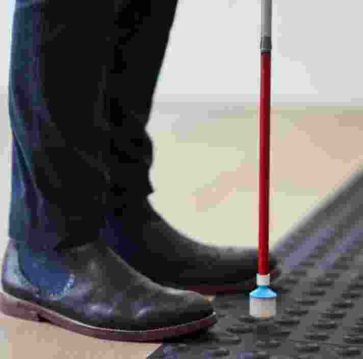 A close up of a cane on tactile markers.
