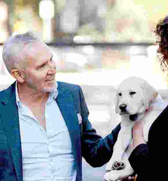 Guide Dogs NSW/ACT CEO Dale Cleaver with a yellow Labrador puppy.