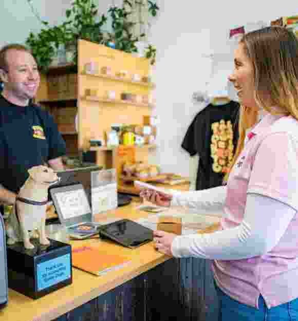 A Donation Dog on the counter with two people standing next to it talking.