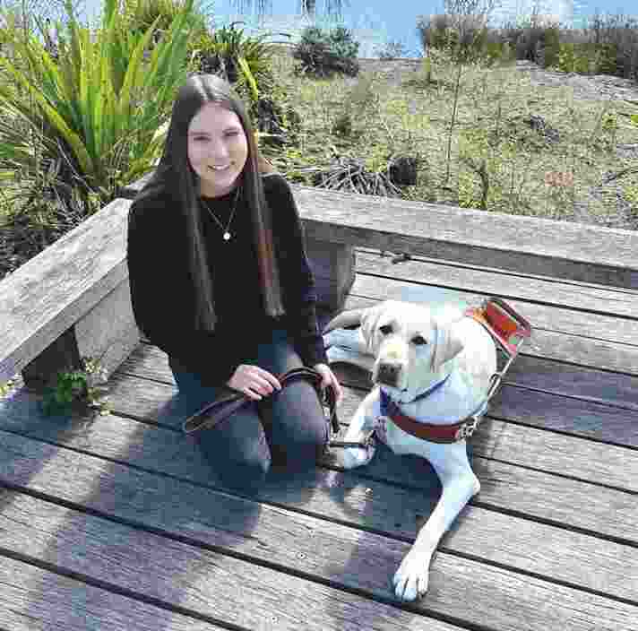 Karlee next to her yellow Labrador Guide Dog Isla.