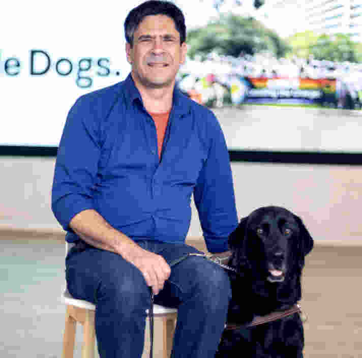 Scott sitting with his black Labrador Guide Dog Dudley.