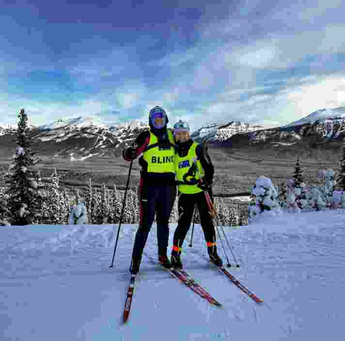 Taryn and her guide on a snow covered mountain wearing skis.