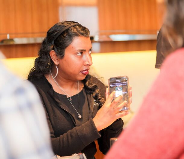 A person holding an iPhone demoing assistive technology.