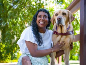 A Handler sitting next to their Guide Dog.