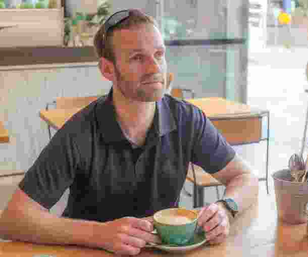 Dan searle sitting at a cafe.