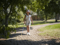 Sora walking with a white cane.