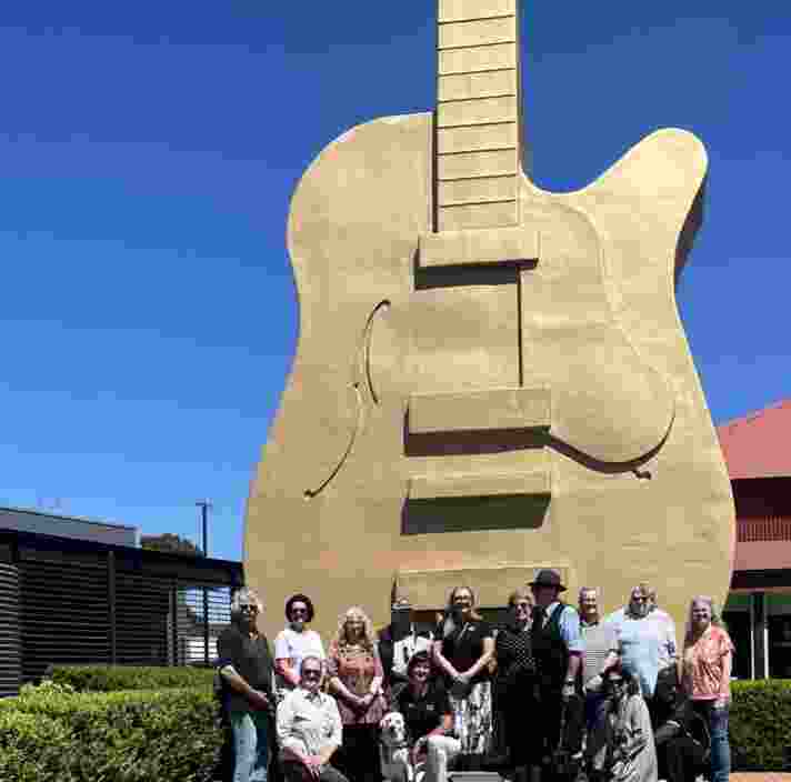A group of people standing in front of the giant guitar in Tamworth