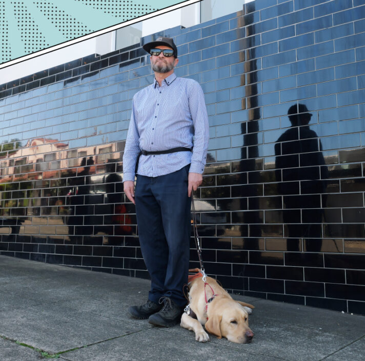 Brian standing outside with yellow Labrador guide dog