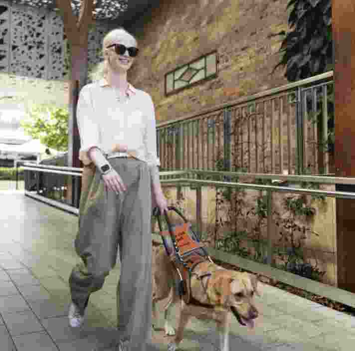 Sacha walking with her guide dog Lorraine
