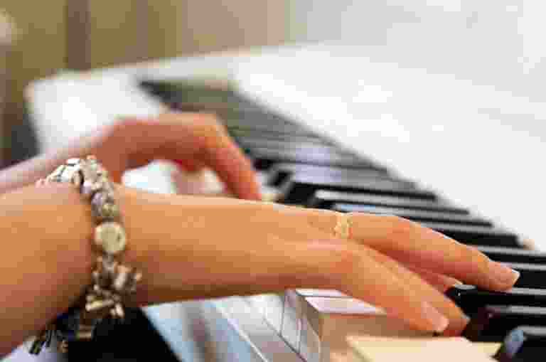 A close-up of hands playing a piano.
