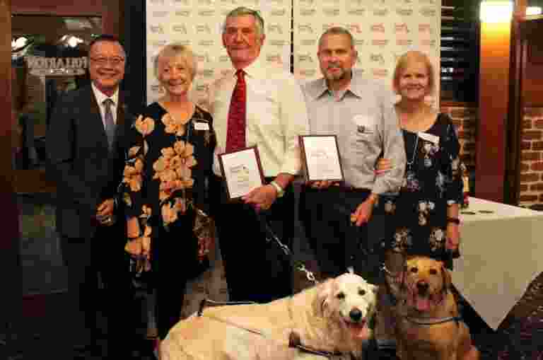 John and Aaron present Neil and Bruce with their awards, alongside their wives and Guide Dogs.