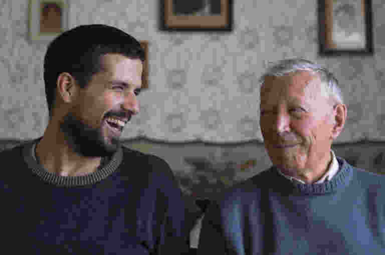 A young man and an older man laughing together