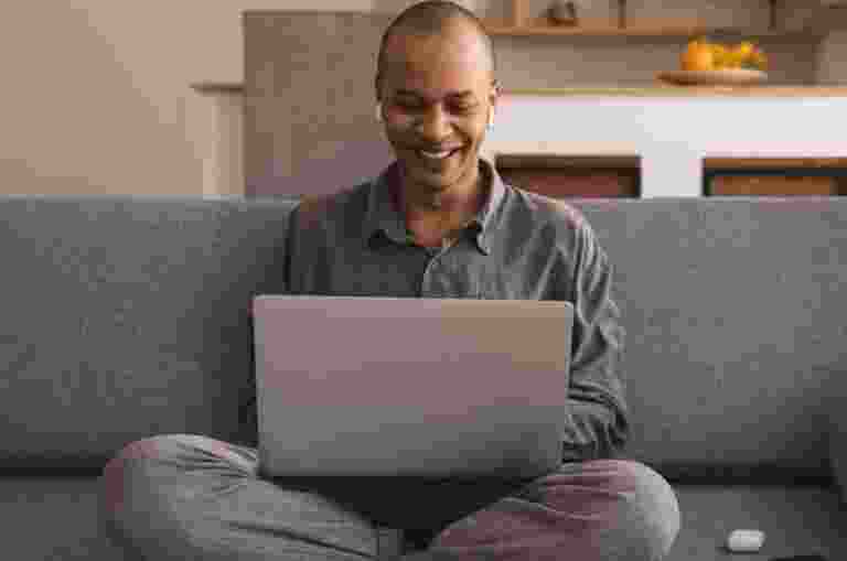 A person in the couch with a laptop