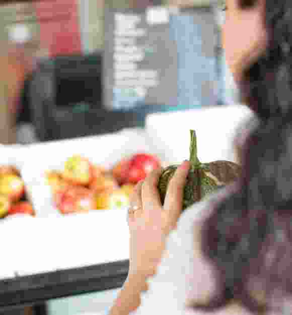 A person holding fresh produce at the market.