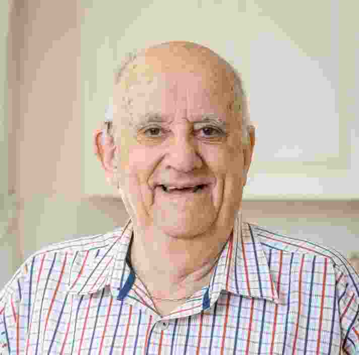 An older adult smiling straight at the camera.