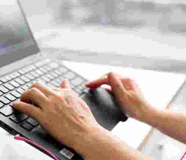 Person's hand using the keyboard of a laptop.