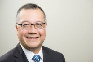 Headshot of Guide Dogs South Australia's Chief Executive Officer, Aaron Chia. Aaron is looking at the camera smiling.