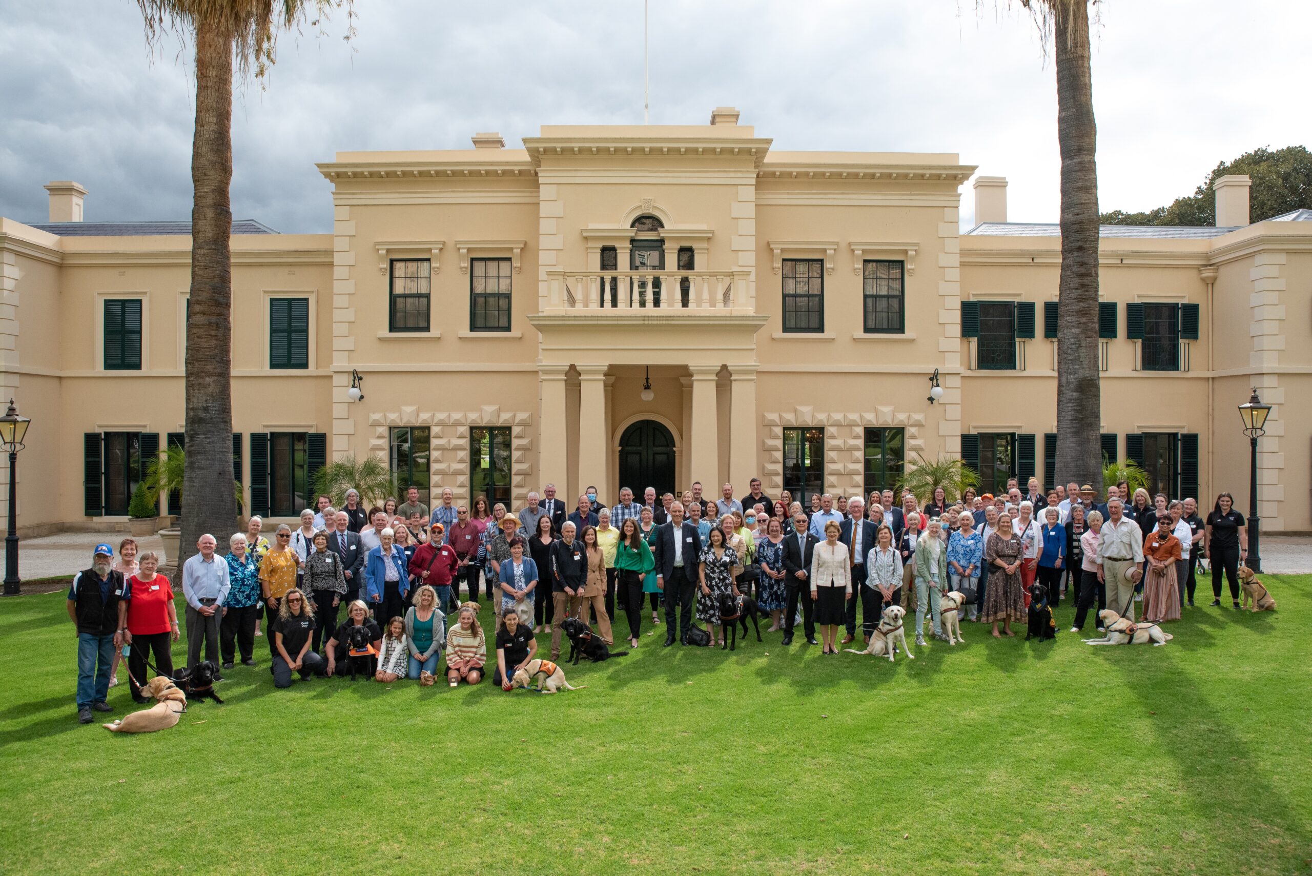 A large group of people standing infront of Goverenment House.