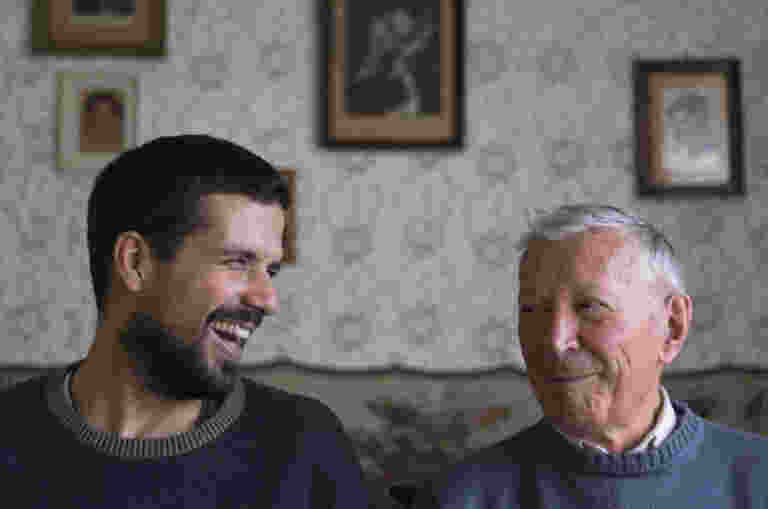Adult and his grandfather looking at each other