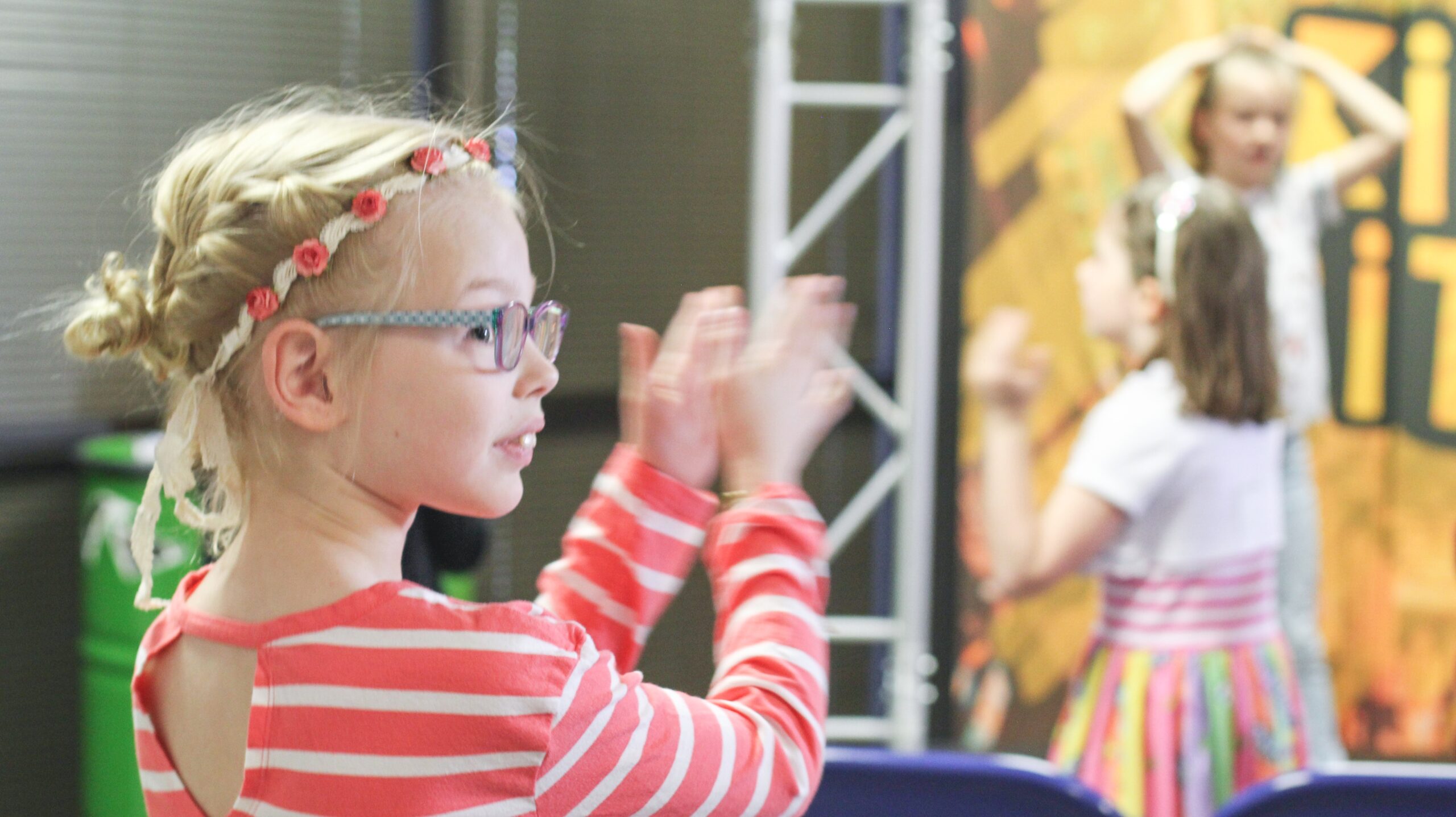 A young girl clapping along to a stage show