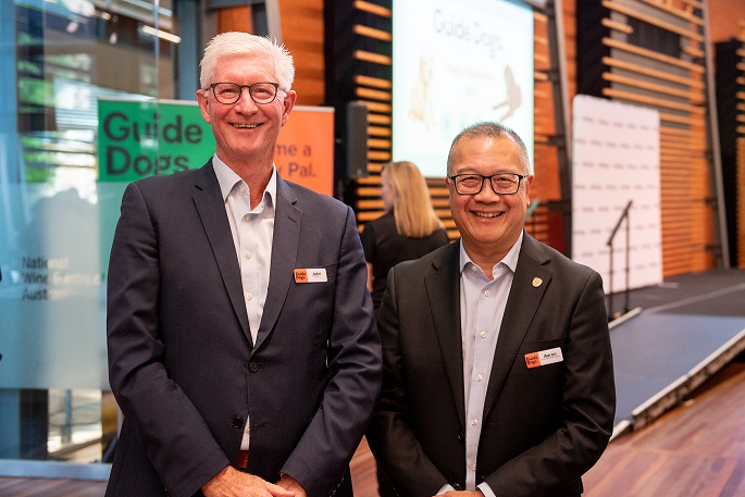 A photo of John Oliver, Chair of the Board, and Aaron Chia, CEO smiling towards the camera together.