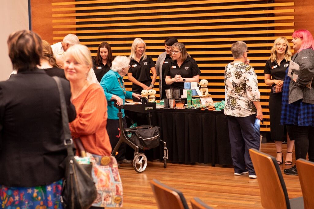 A photo of Guide Dogs staff serving supporters purchasing merchandise.