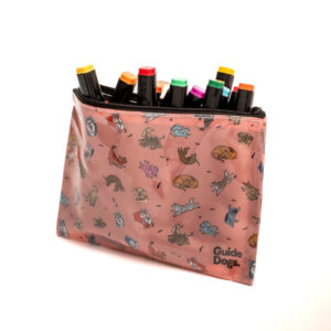 A pink zippered pouch with cartoon animal illustrations, filled with colorful markers, and the words Guide Dogs printed at the corner.