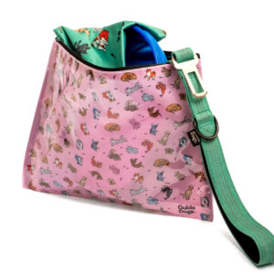 A pink bag with cartoon dogs, a green strap, and a green fabric partially visible inside.