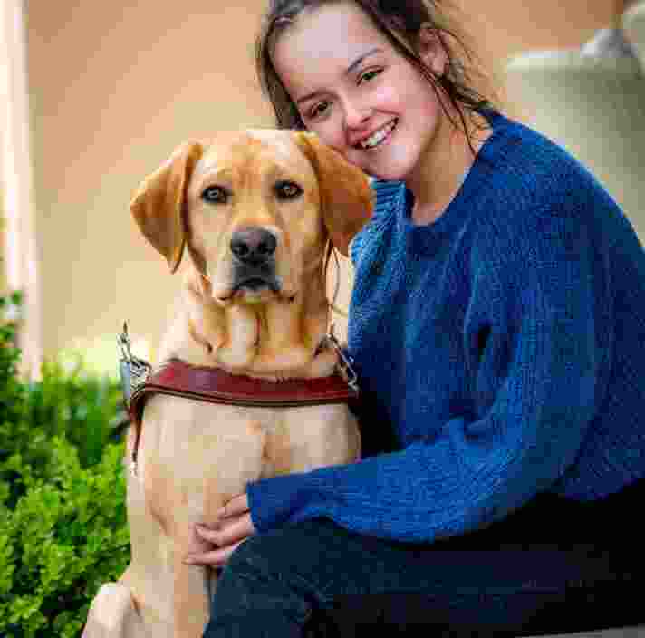 The photos show Emily smiling towards the camera. Tanner, her Guide Dog is sitting close to her.
