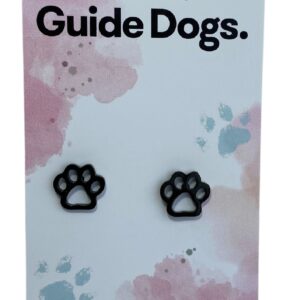 The image shows a black paw-shaped earring on a card that reads "Proudly supporting Guide Dogs." The card has a pastel background with pink and blue splotches and small paw print designs. At the bottom, it states, "Handcrafted & made from stainless steel."