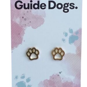 The image shows a gold paw-shaped earring on a card that reads "Proudly supporting Guide Dogs." The card has a pastel background with pink and blue splotches and small paw print designs. At the bottom, it states, "Handcrafted & made from stainless steel."