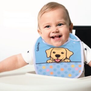 A smiling baby wearing a Baby Bib featuring a cartoon puppy design sits in a high chair.