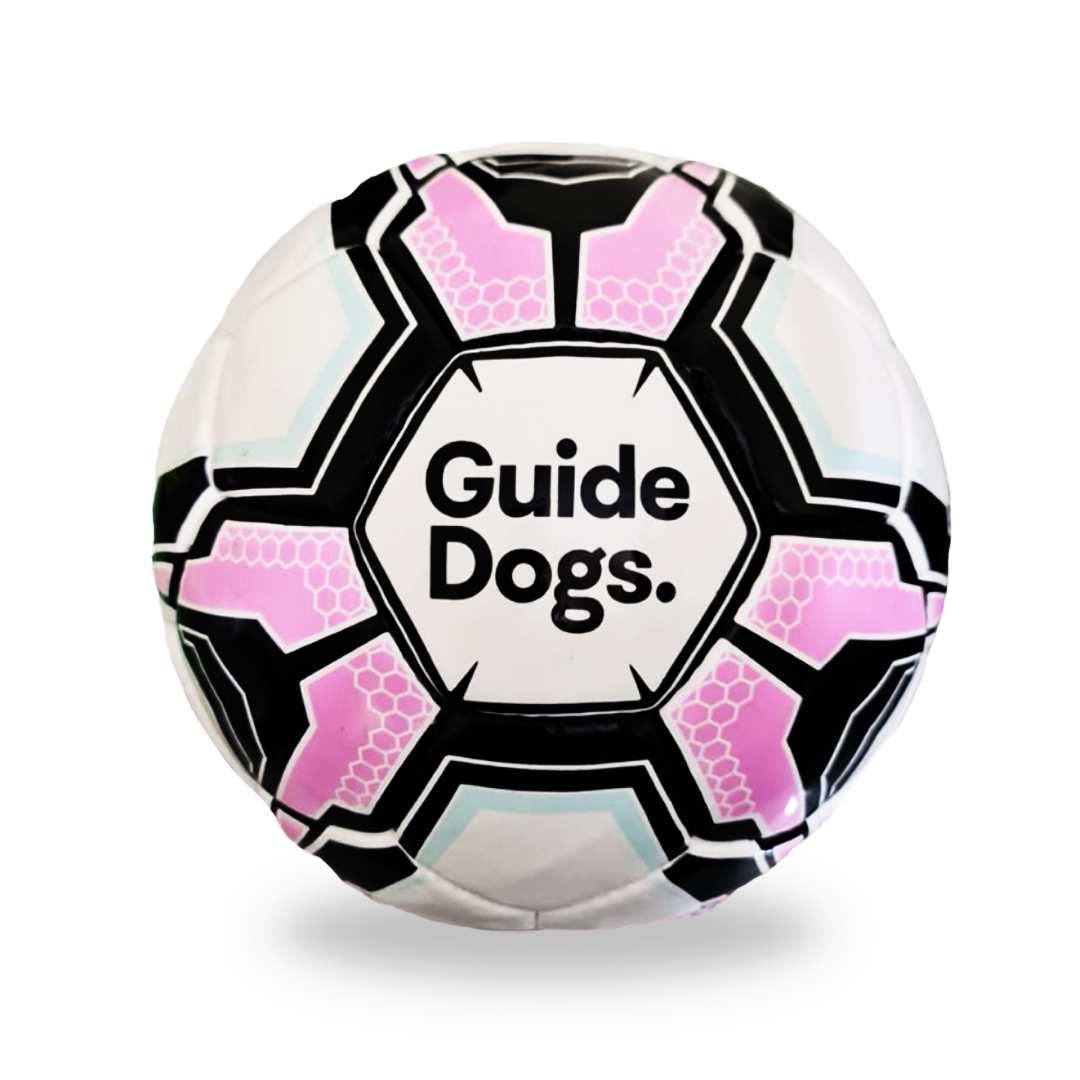 An Audible Soccer Ball featuring a black, white, and pink geometric pattern with the words Guide Dogs in the center.