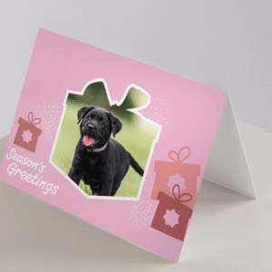 The Christmas Cards - Puppies feature a pink holiday design with a black puppy photo in a gift-shaped frame, Seasons Greetings, and two gift box illustrations.