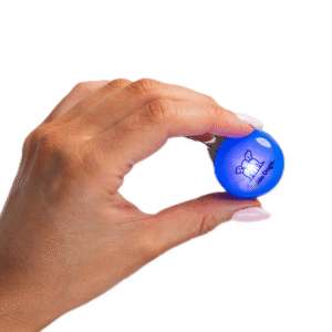 A hand holds a blue circular Clip on LED Light featuring a dog graphic and the text collarbone, against a white background.