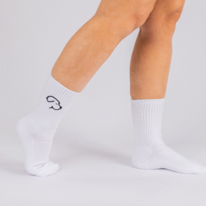 Model wearing Crew Socks - White, featuring a simple black outlined design on the side, standing against a white background.