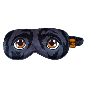 The Eye Mask is black with a printed design of dog eyes and fur, and features an orange Guide Dogs tag on the side.