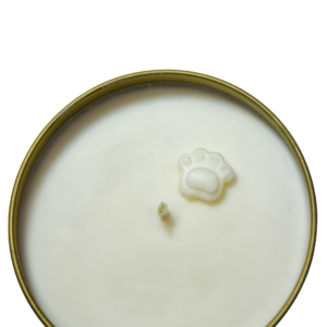 The Candle Tin - Gold is a round white candle in a metal tin, featuring a small paw print-shaped wax decoration on top.