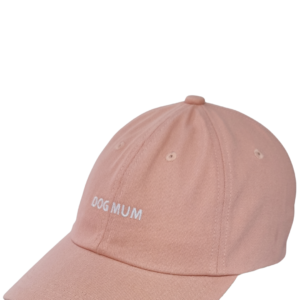A light pink Caps baseball cap featuring "DOG MUM" embroidered in white on the front.