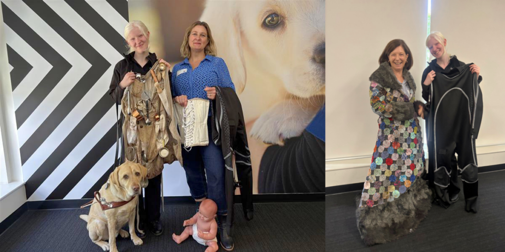 Three women pose indoors with a guide dog and a doll, holding or wearing clothing items, including a patchwork coat and textured garments; a large dog photo is visible in the background.