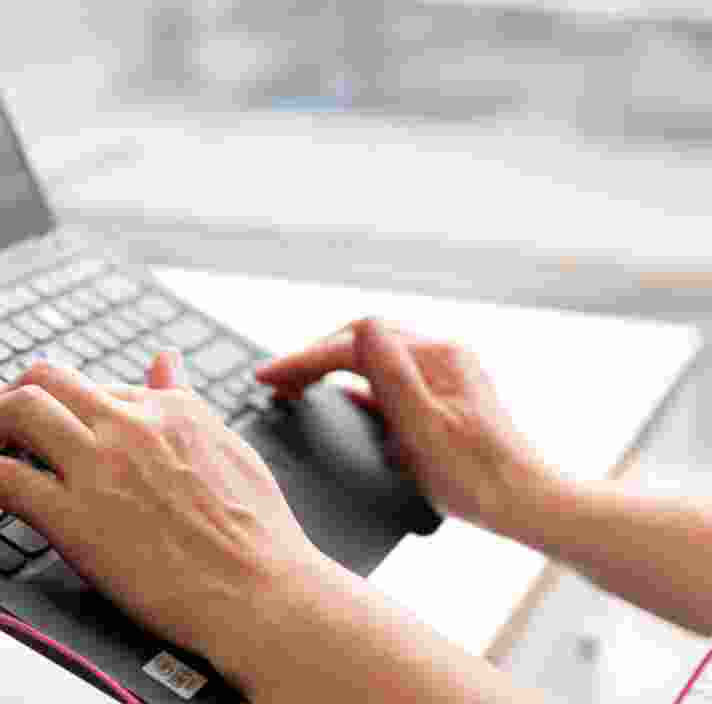 Person's hand using the keyboard of a laptop.