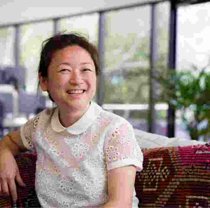 A person sitting in a cafe smiling at the camera.