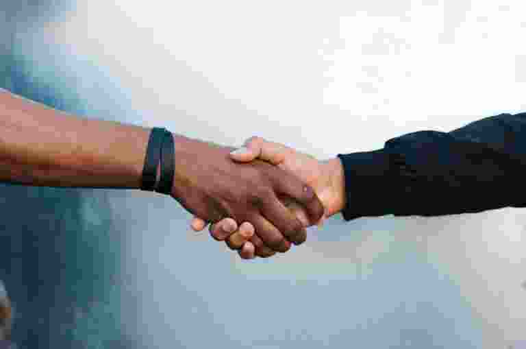 A close up image of two people shaking hands.