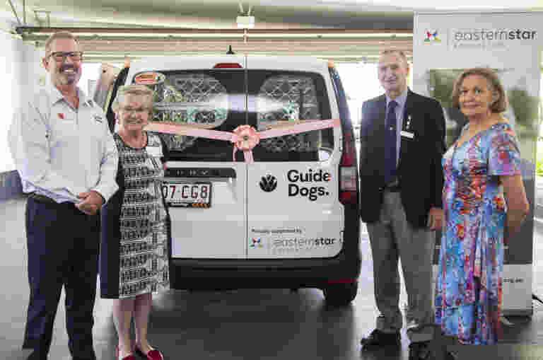 image of Michael Kightly, Guide Dogs CEO and three Eastern Star Foundation Directors in front of Guide Dog's new car. An Eastern Star foundation banner is in the backgroud