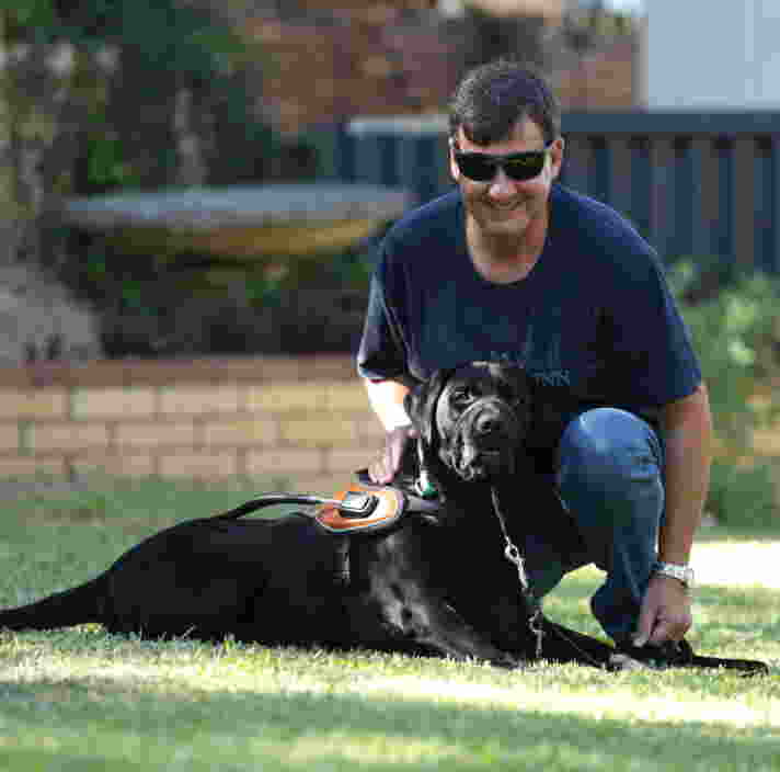 Image of Jason and Tyson sitting on the grass, looking at the camera.