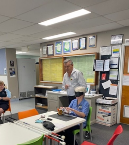 A Orientation and Mobility Specialist from Guide Dogs Queensland, educating staff from Rockhampton hospital with tactile objects, canes and other mobility aids.