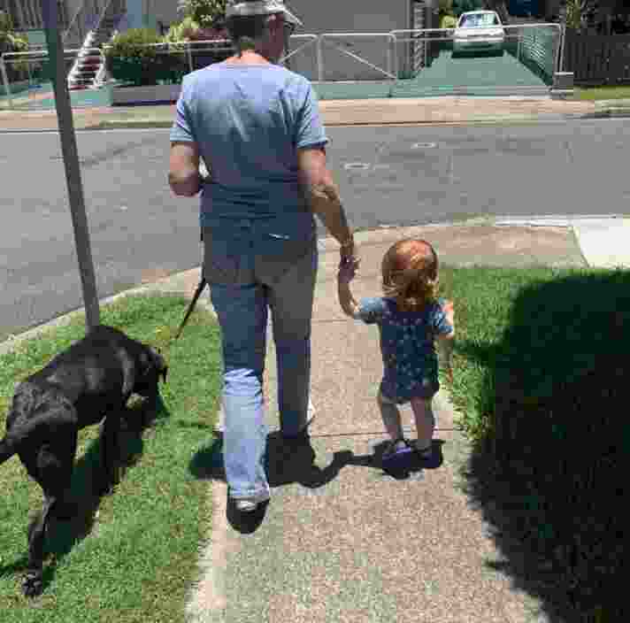 image of an adult walking with a child and a dog.